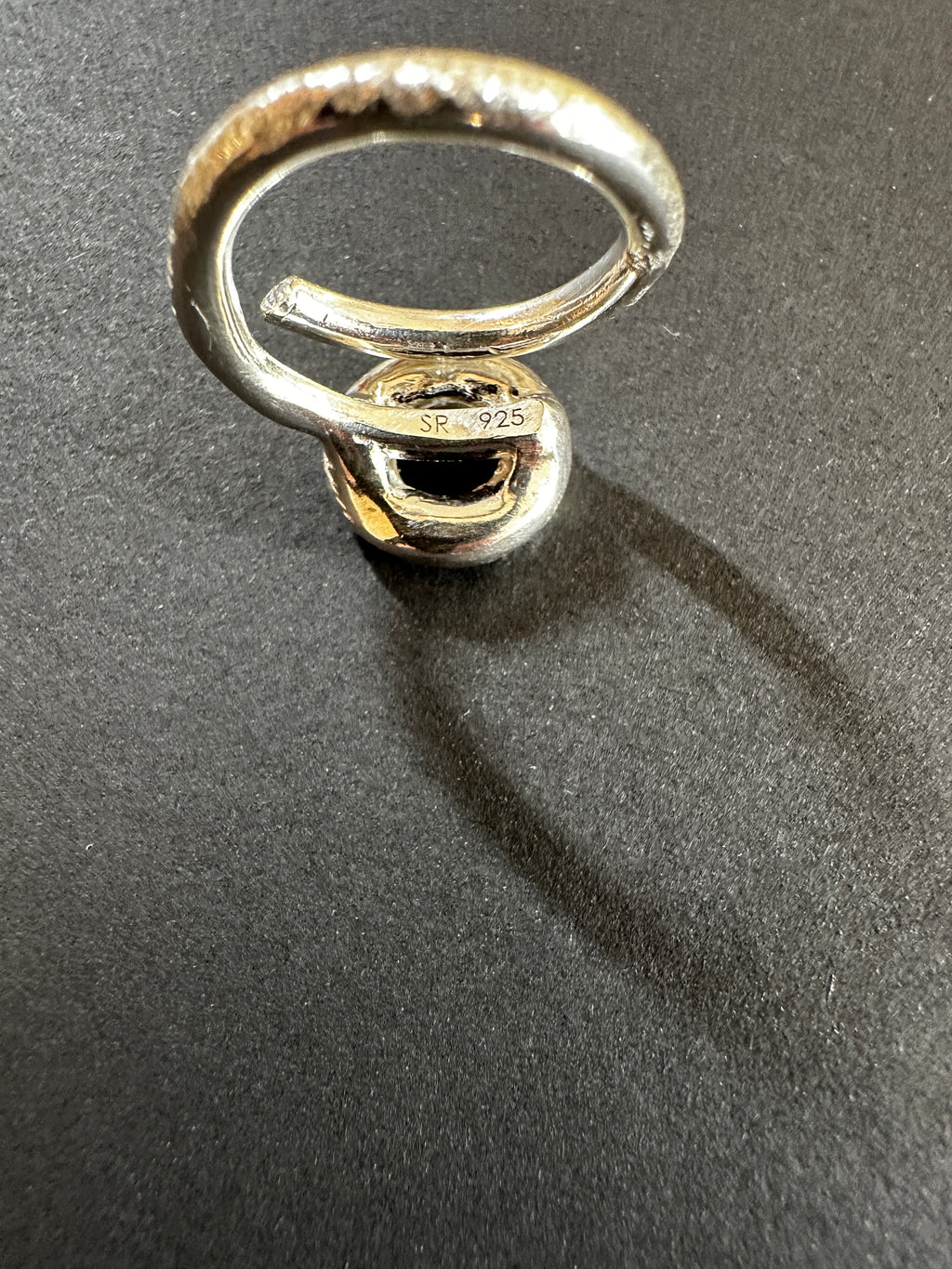 Silver circle rings stacked on a dark gray surface