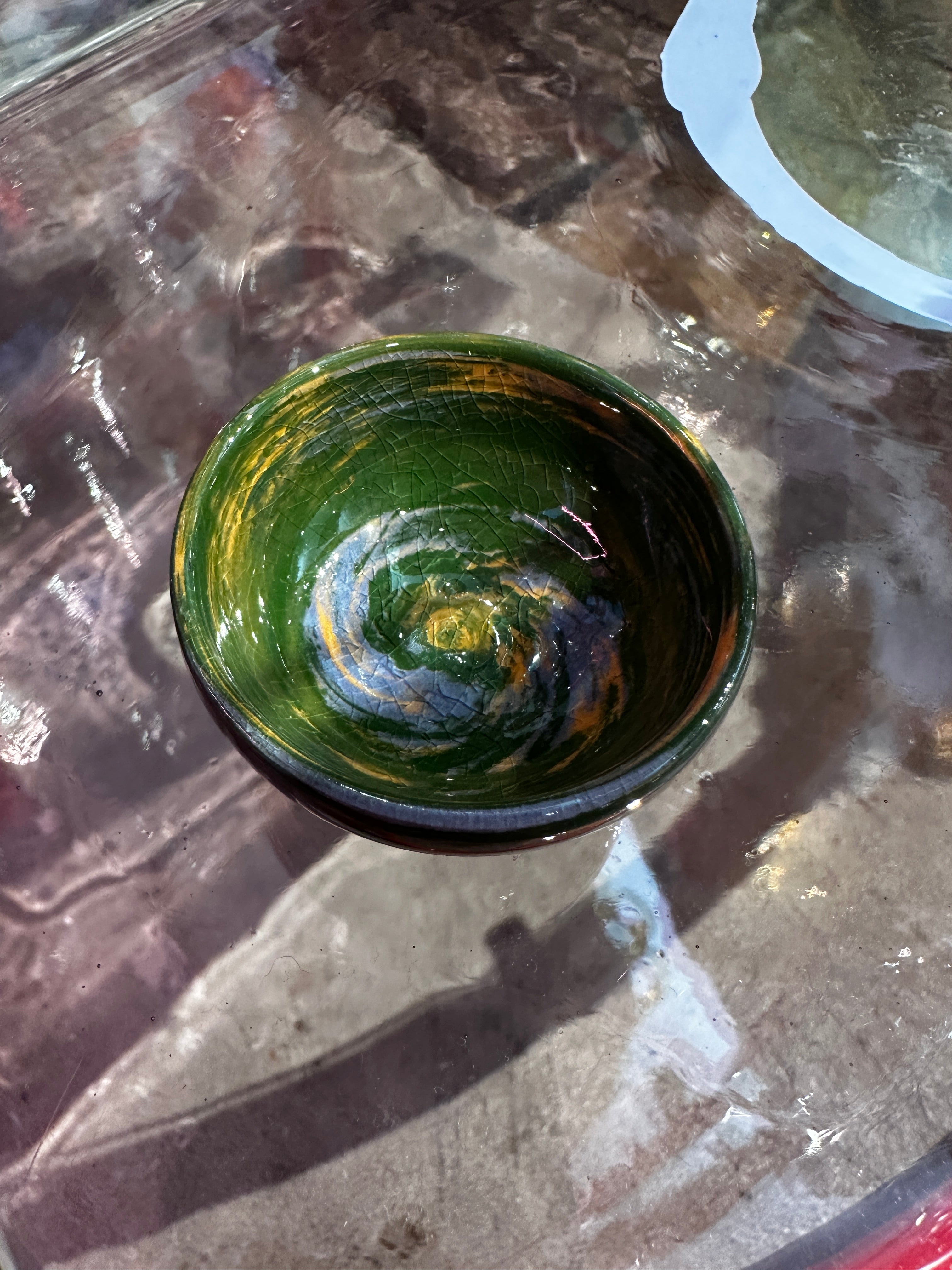Green ceramic bowl on a textured surface