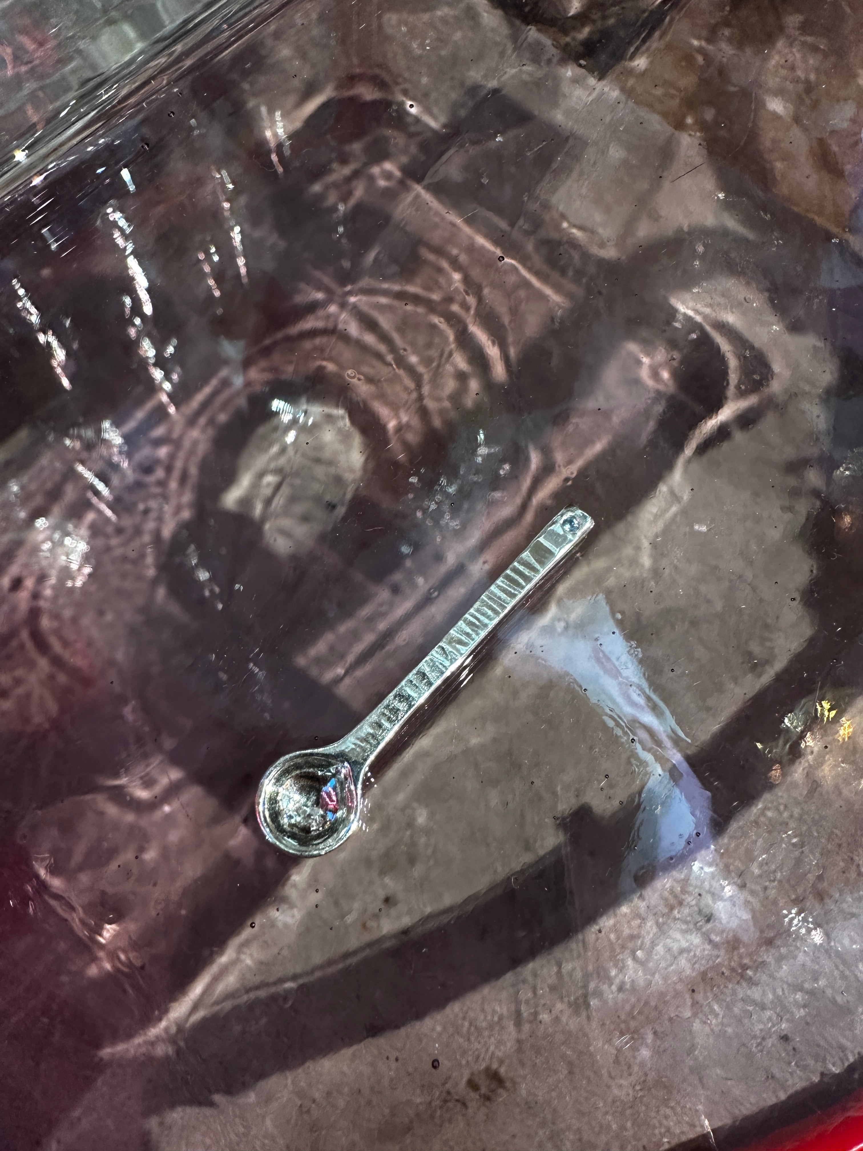 Silver salt spoon on a reflective surface