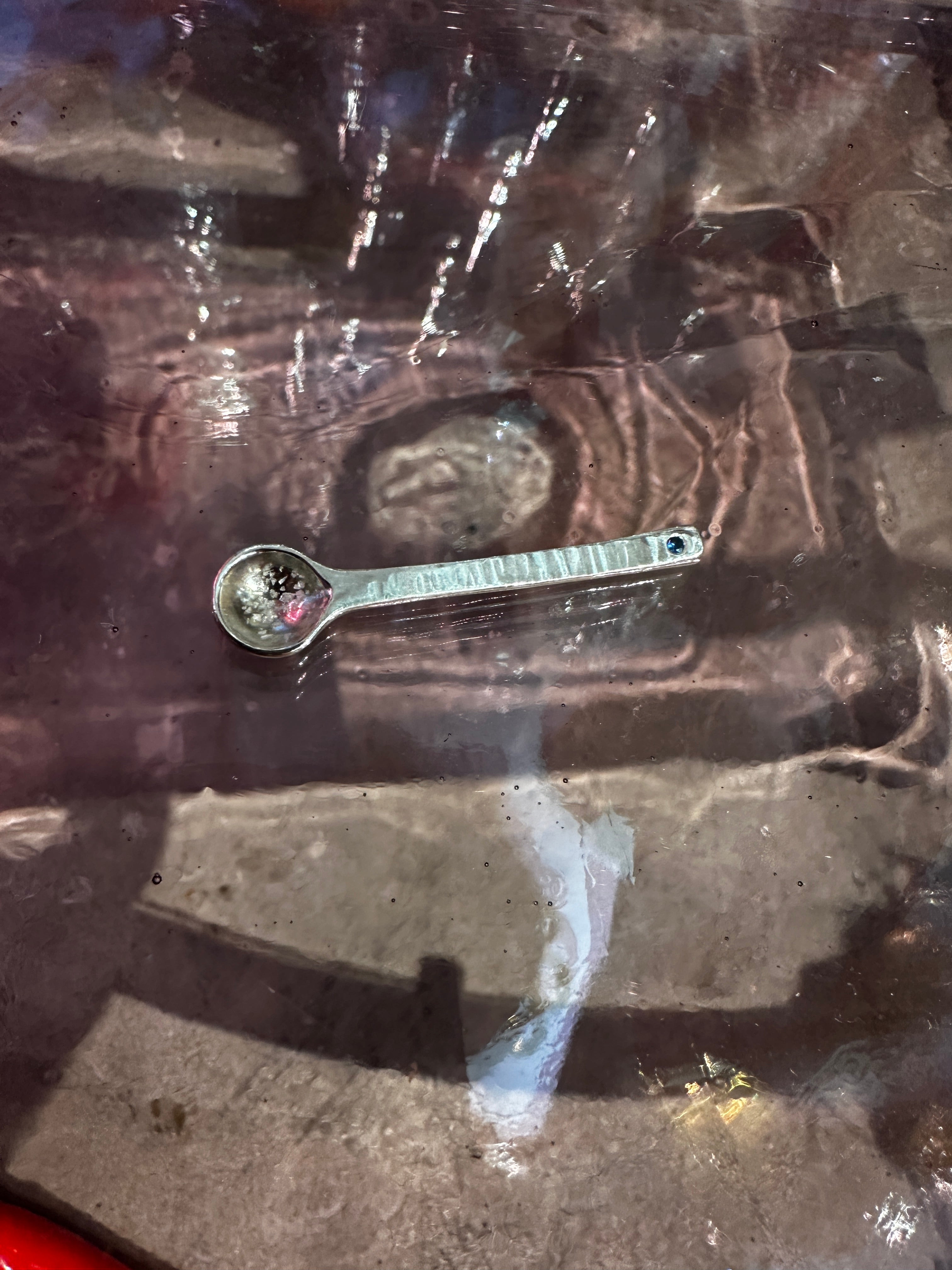 Silver salt spoon on reflective surface